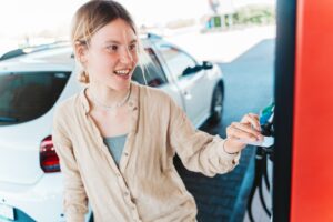 Woman at the gas station pays with the credit card